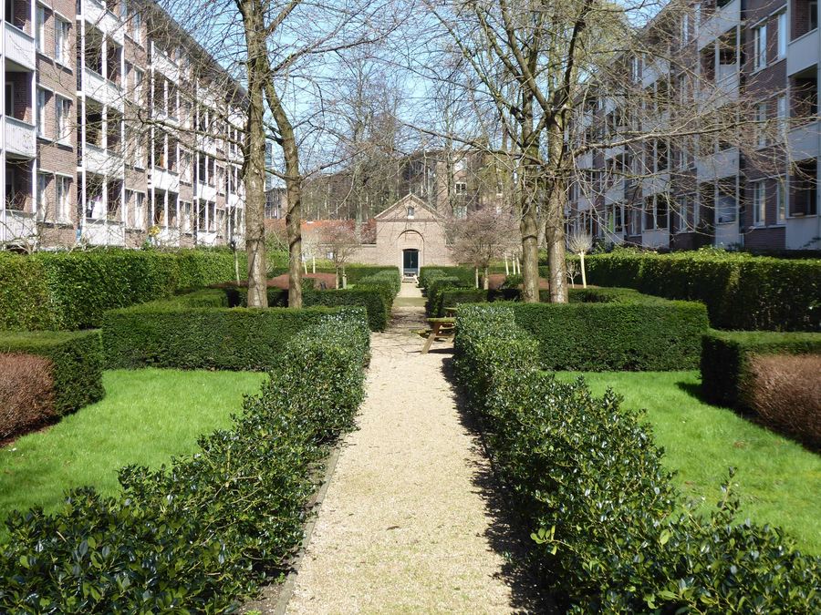 Gepflegter Innenhof mit geschnittener Hecke und gemähtem Rasen