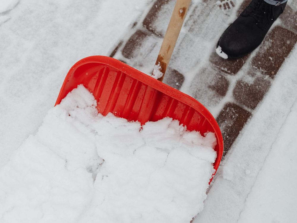 Schneeschaufel auf einem geräumten Gehsteig